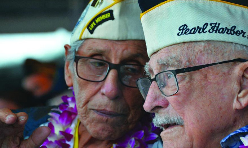 Robert Fernandez, left, chats with fellow Pearl Harbor survivor George Keene at the Pearl Harbor Visitor Center, Dec. 7, 2018. (Wyatt Olson/Stars and Stripes)