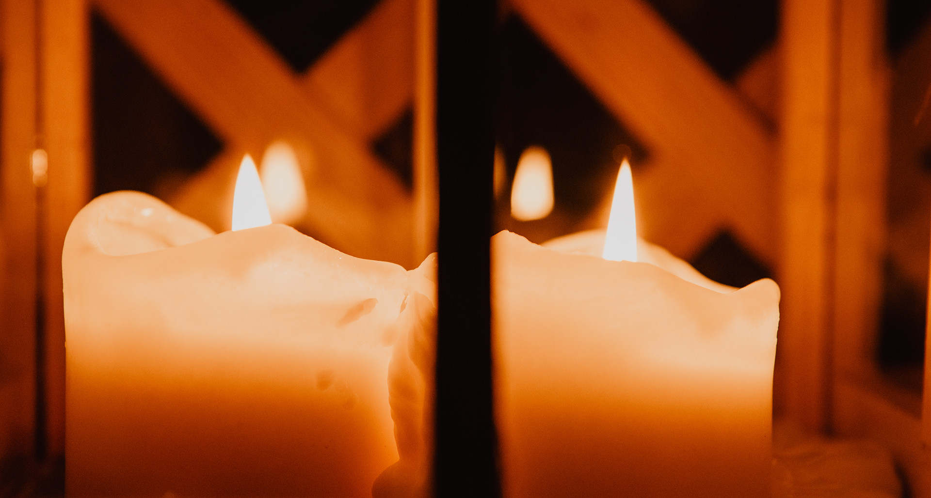 Closeup flaming candles placed in candelabrum between obscurity